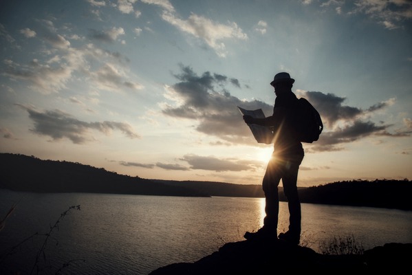 tourist making photo of the nature, man with map exploring wilde